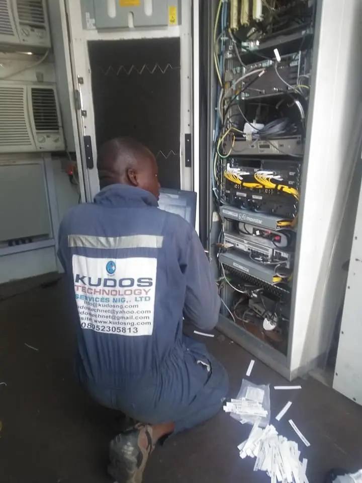 Kudos site engineer working inside a network equipment cabinet