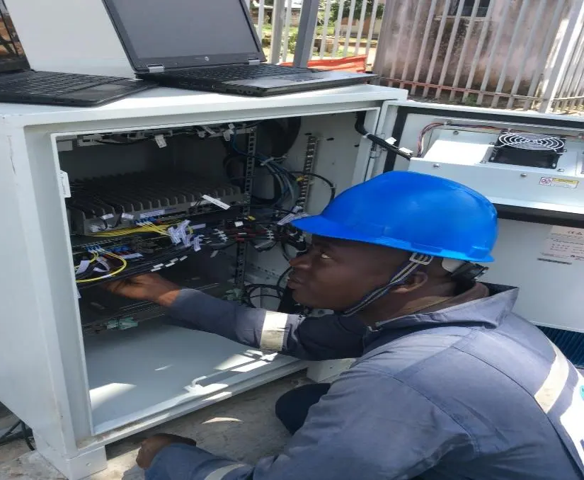 Kudos network engineer working inside an equipment rack